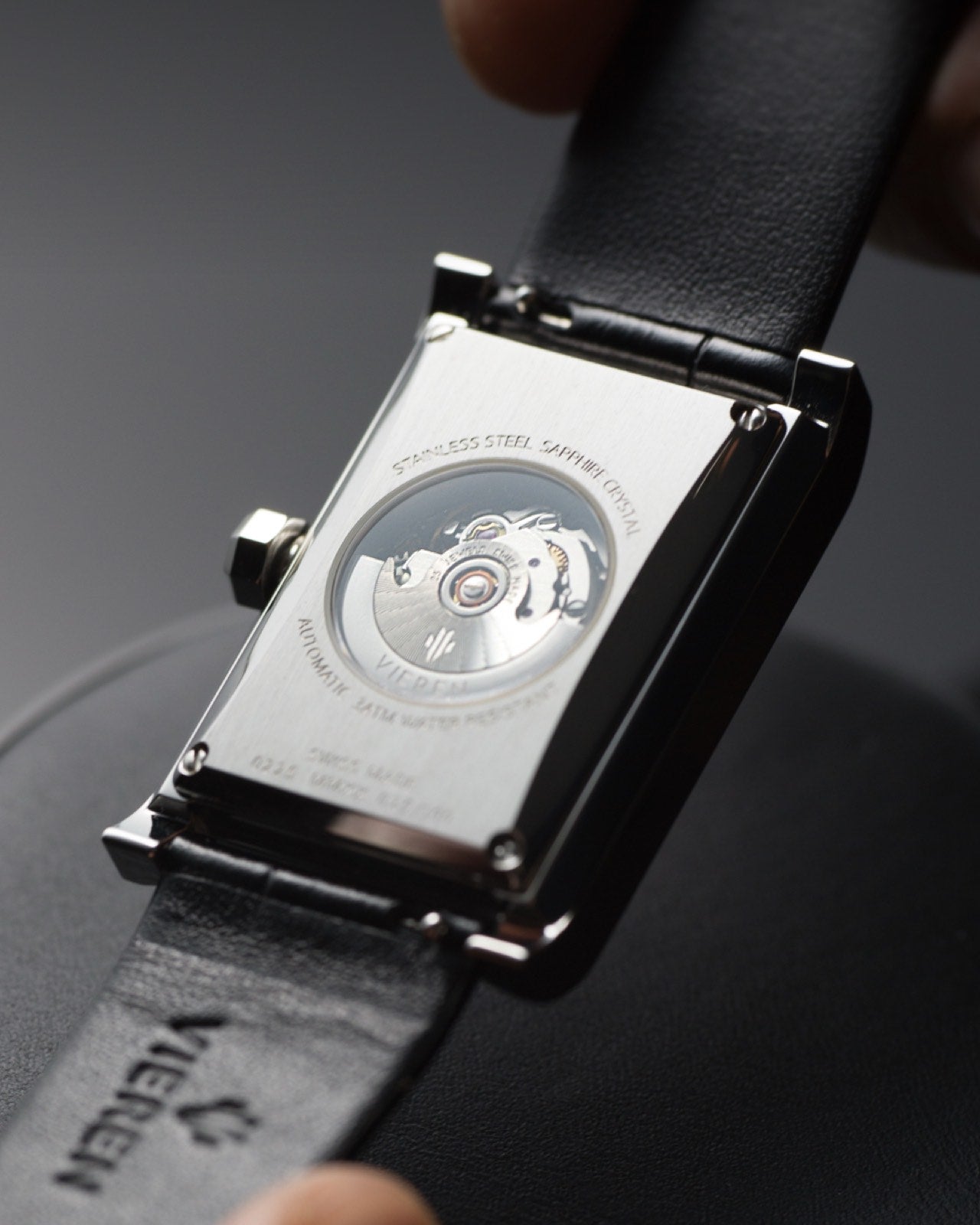 Leather rectangular automatic watch caseback showing the Swiss automatic movement