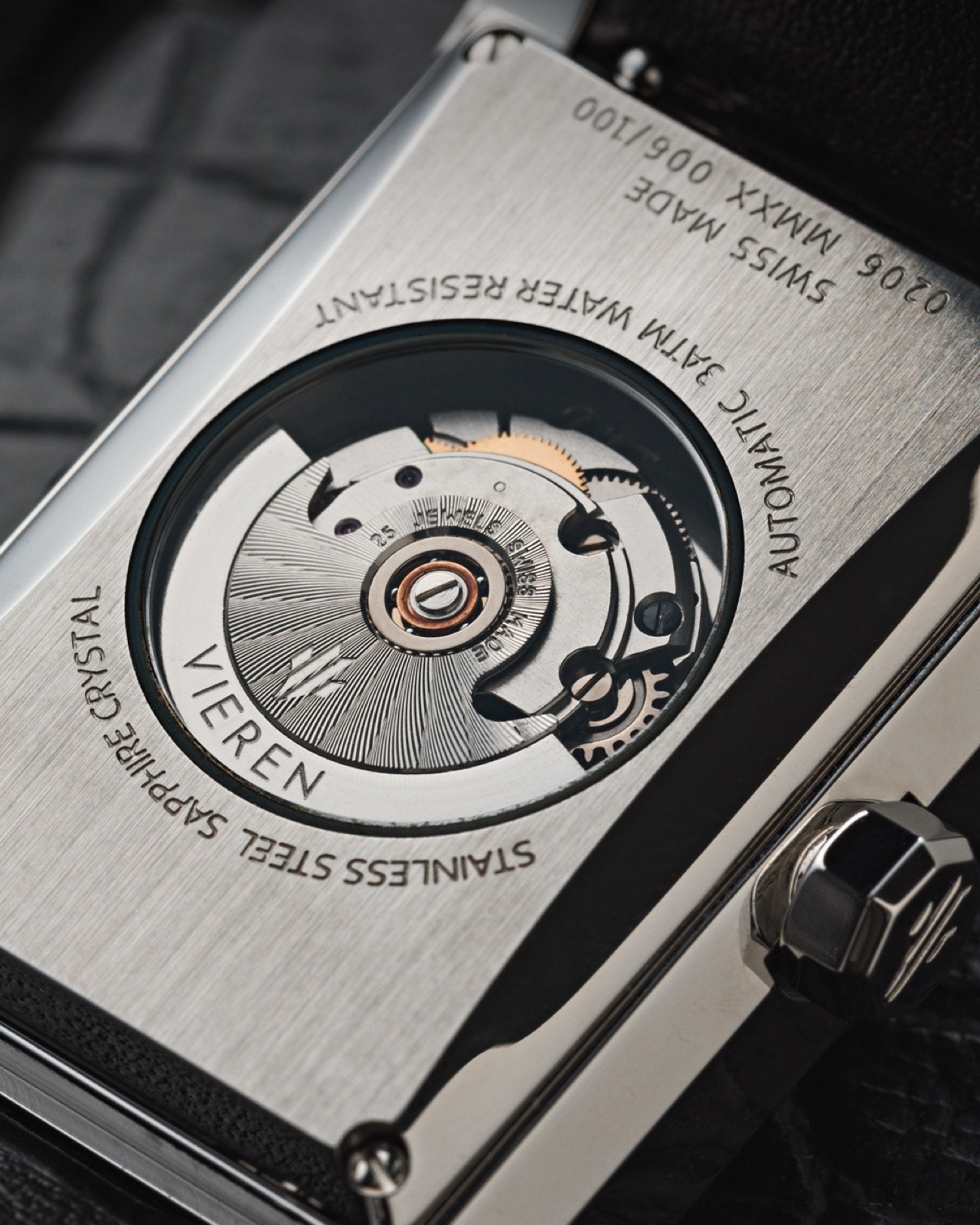 Luxury Swiss automatic watch movement caseback with silver rectangular case and leather strap