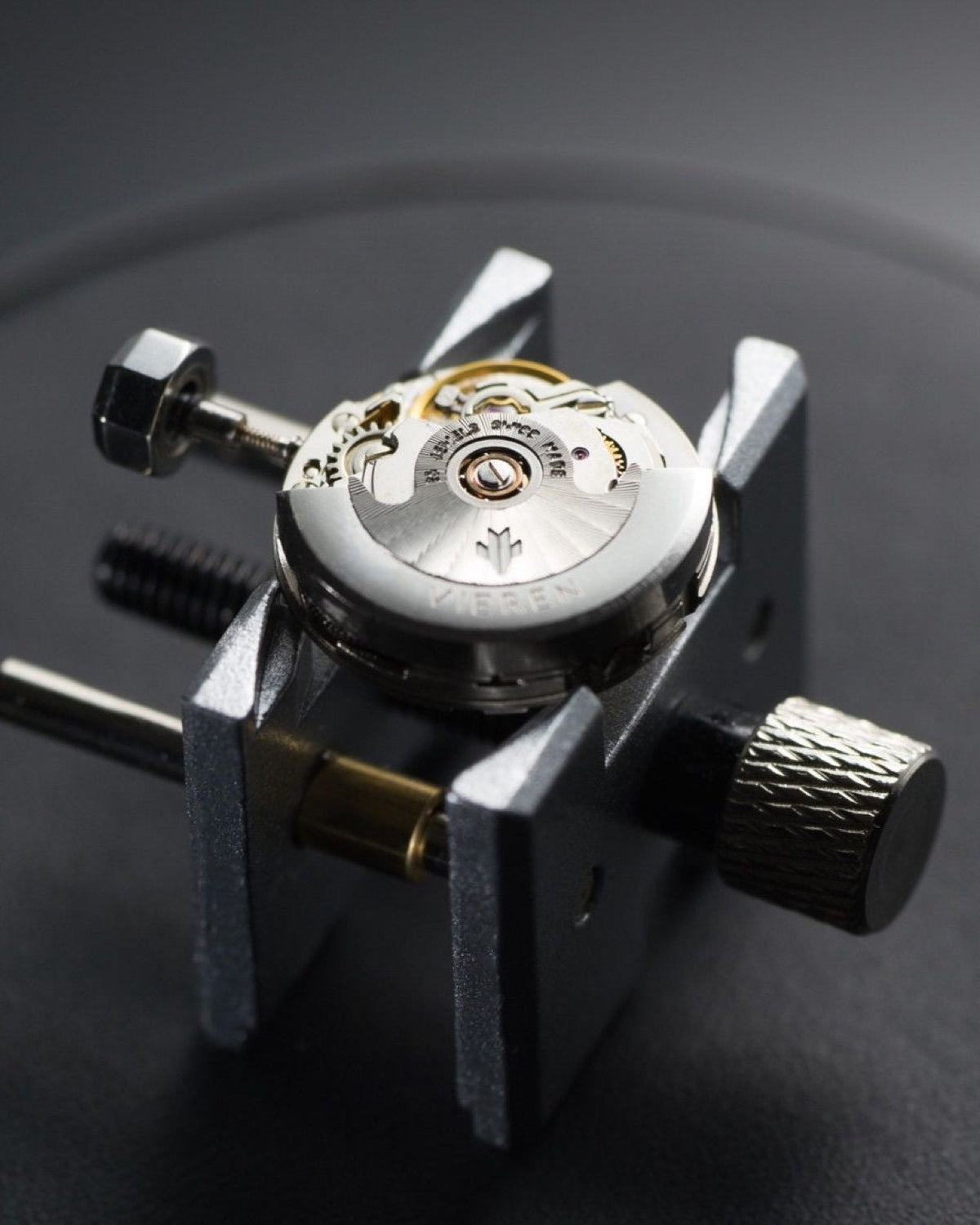 Swiss automatic watch movement with silver rotor on stand