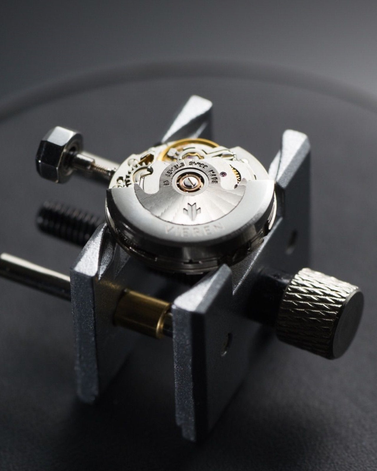 Swiss automatic watch movement with silver rotor on stand