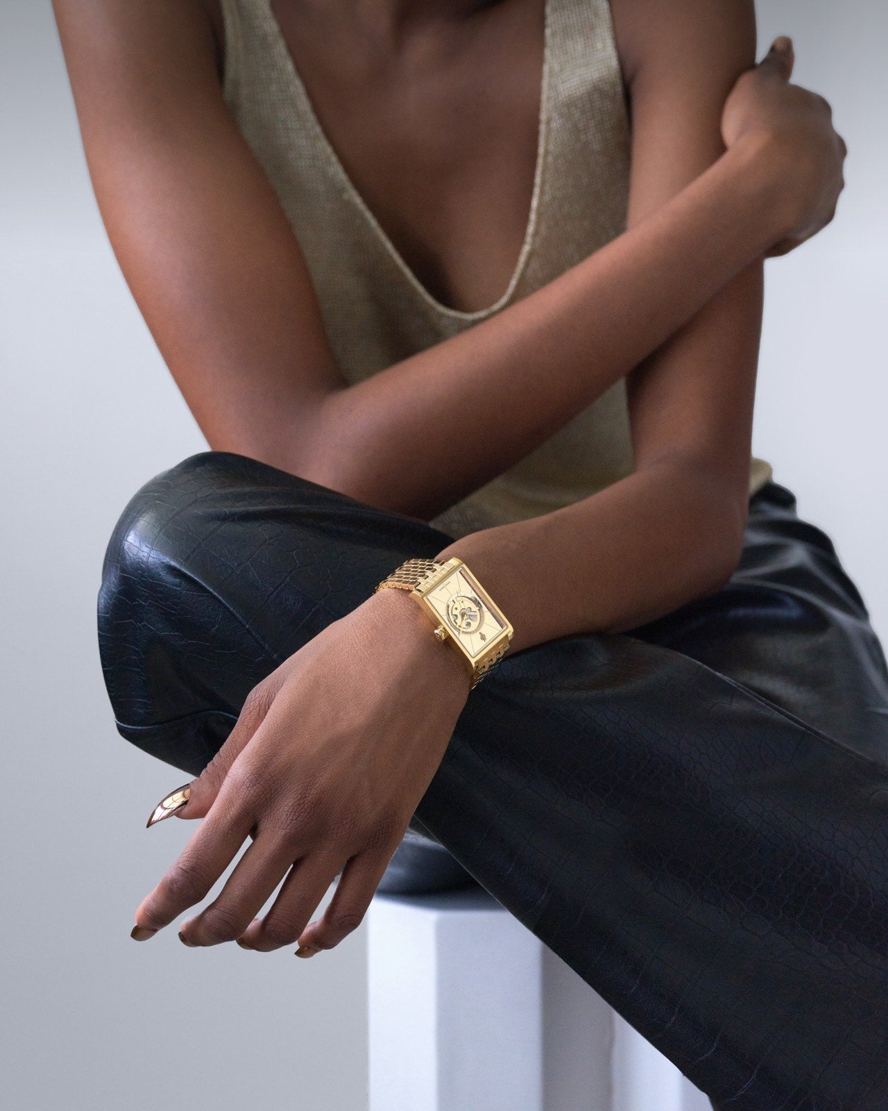 Luxury Swiss automatic gold rectangular women’s watch styled with black leather pants