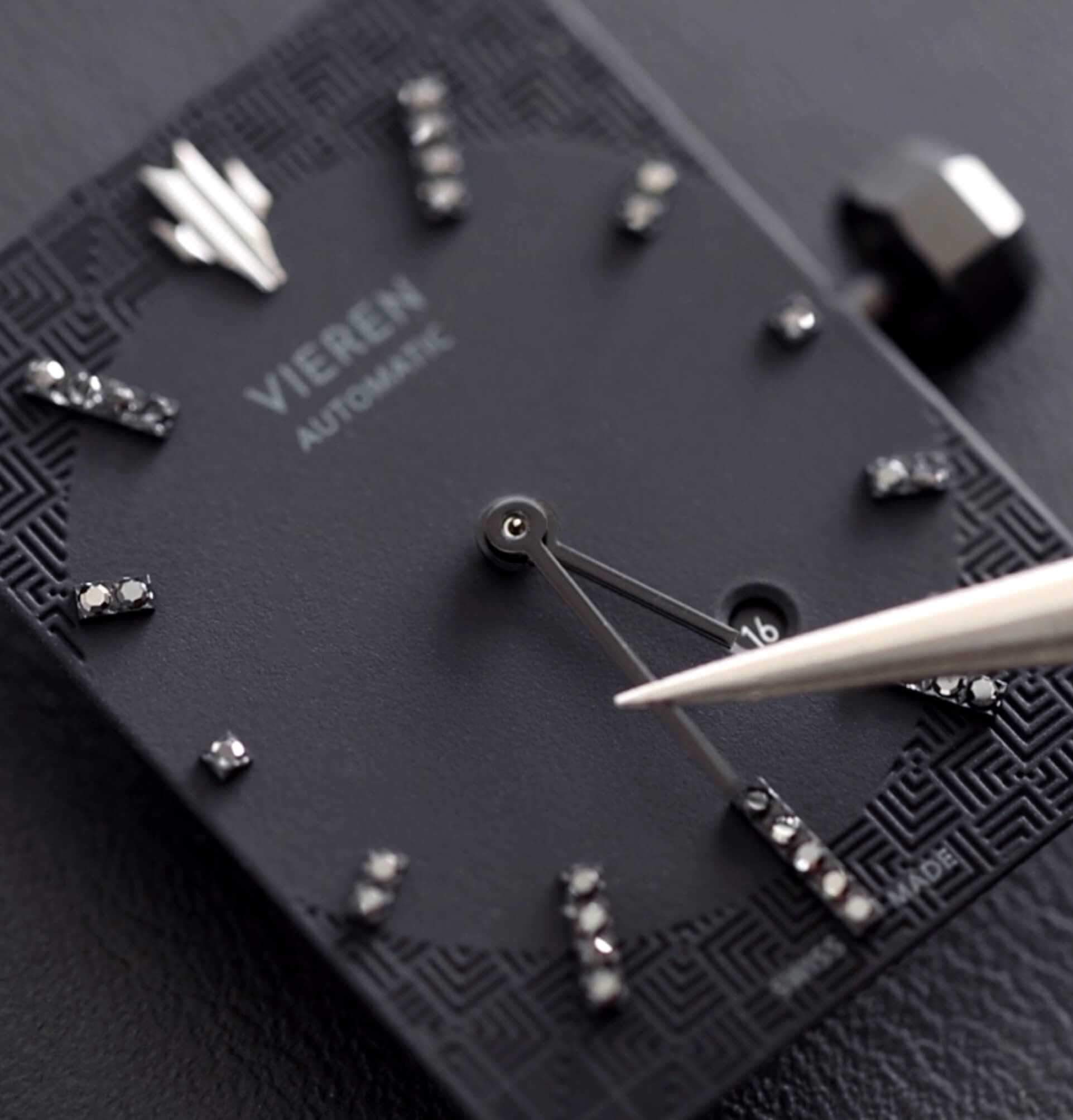 VIEREN black rectangular watch dial with diamonds and watch hands being assembled