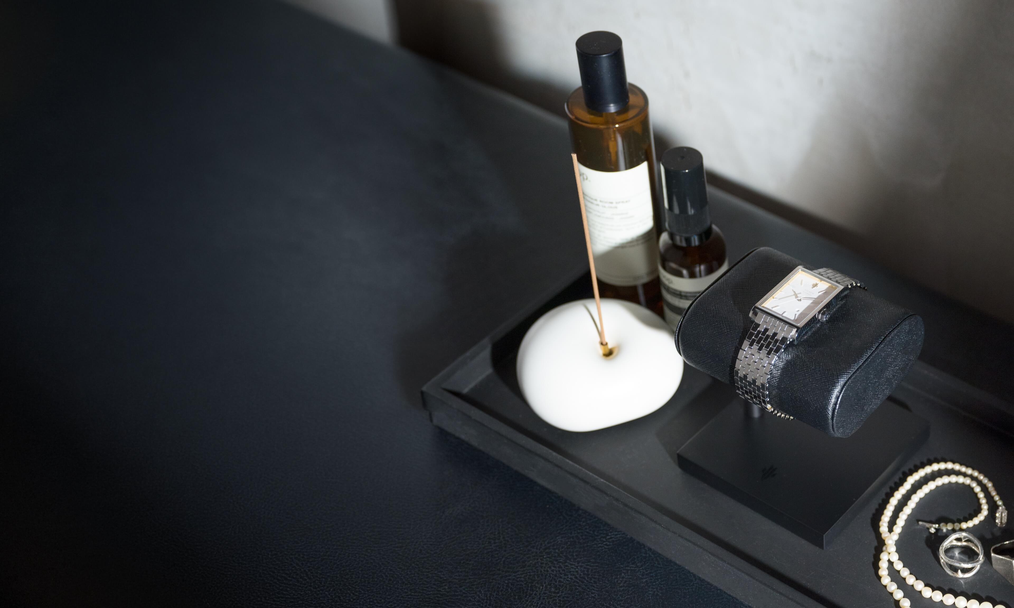 VIEREN Silver rectangular watch displayed on watch stand with accessories in a lifestyle setting