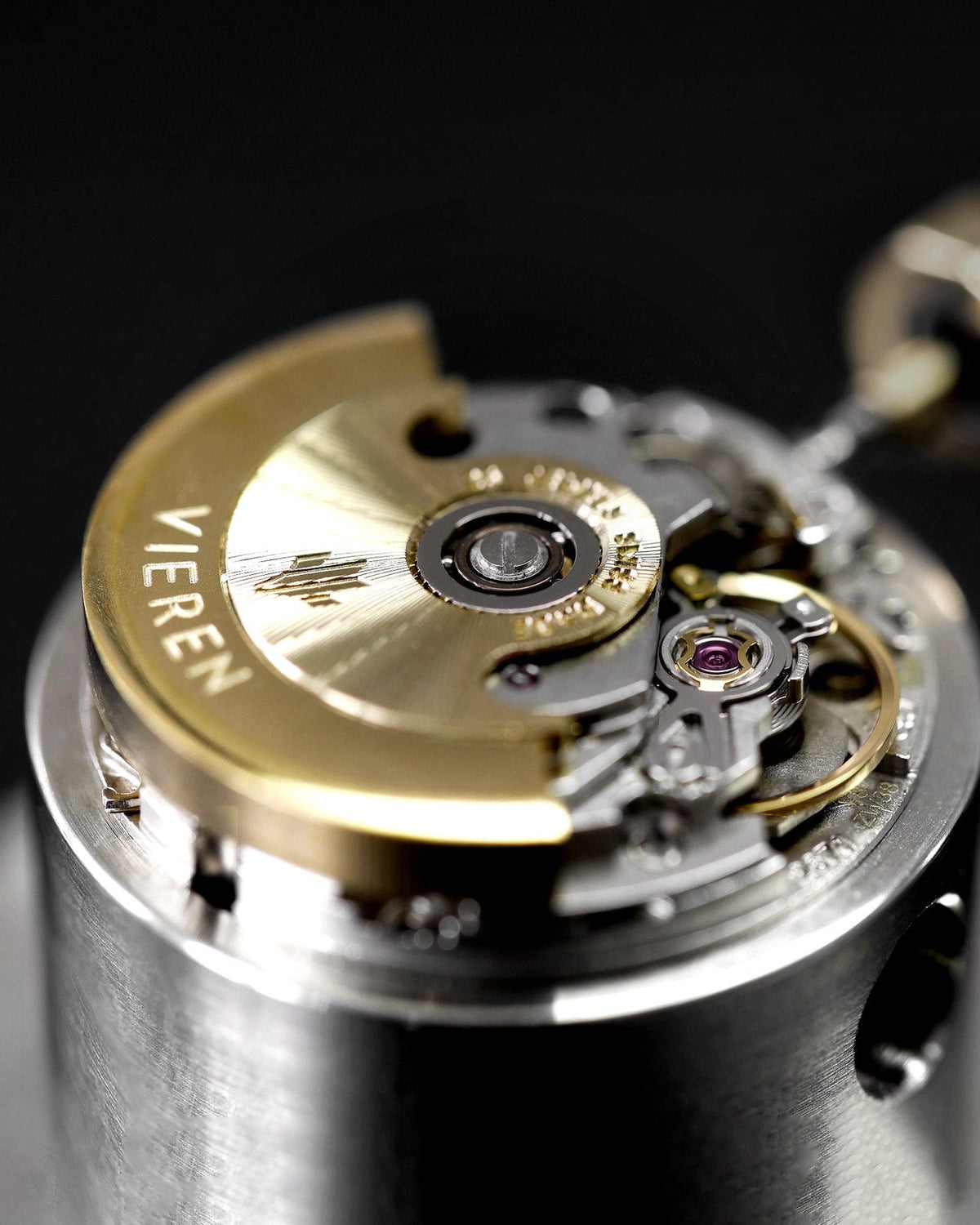 Close-up of Swiss ETA 2671 automatic watch movement with gold rotor, balance wheel, and jewels