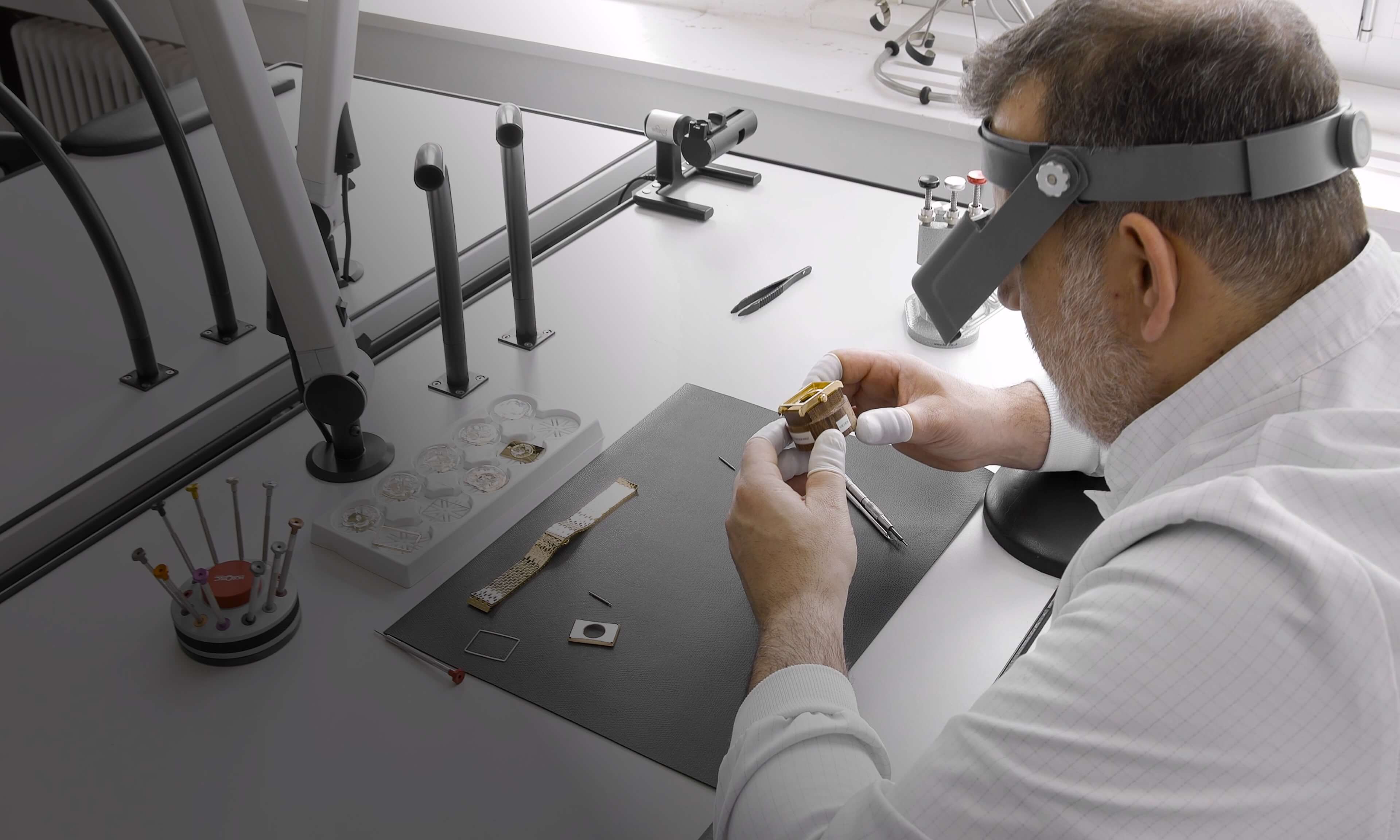Swiss watchmaker crafting VIEREN gold rectangular watch case with precision tools